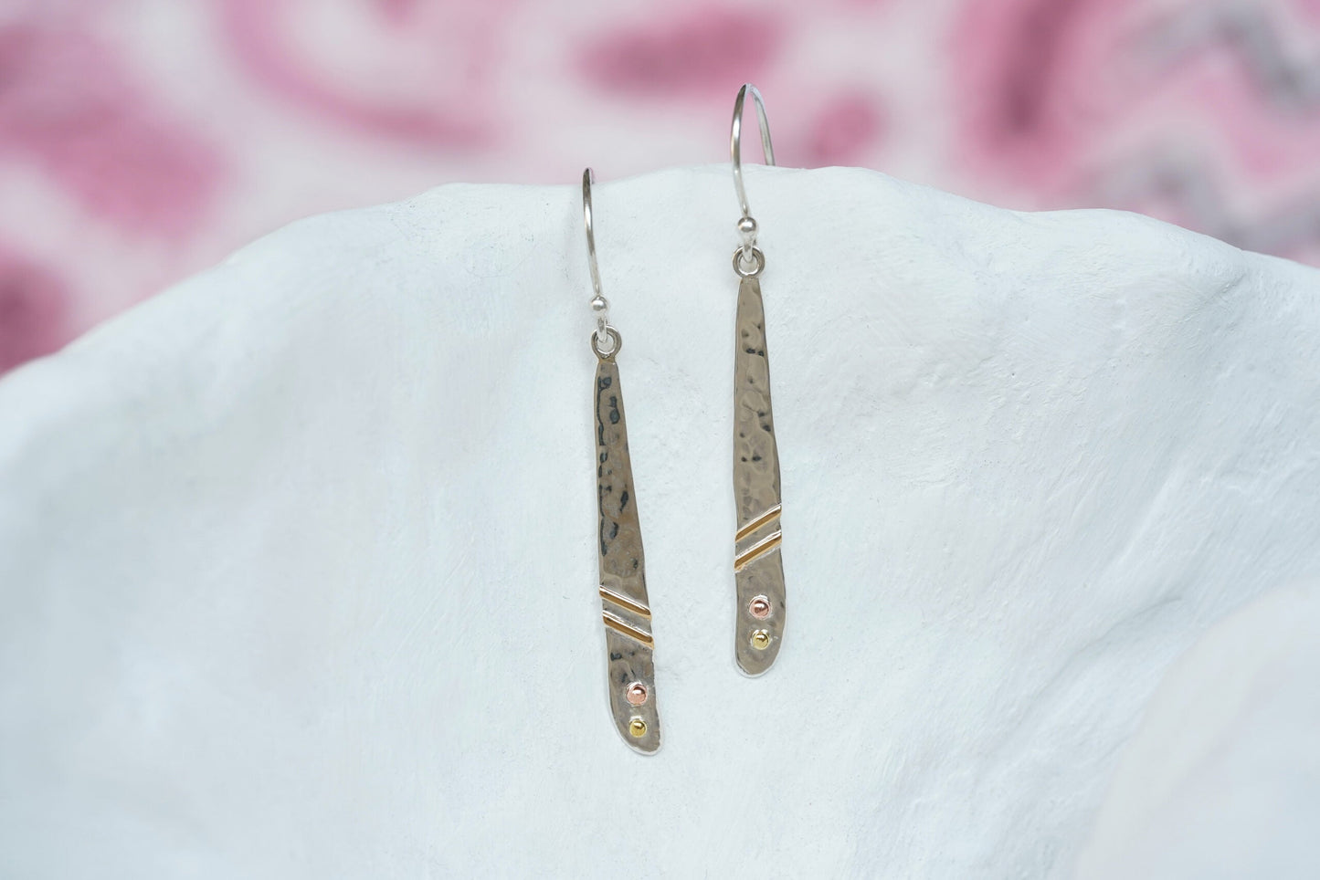 Sterling Textured Silver Brass & Copper Detail Drop Earrings on a white surface with pink floral background