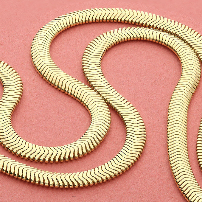 Sterling Silver 14ct Gold Vermeil Flat Oval Snake Chain Bracelet with a wavy pattern on a pink background