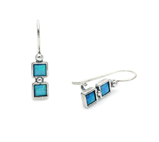 Silver earrings with blue square stones on a white background