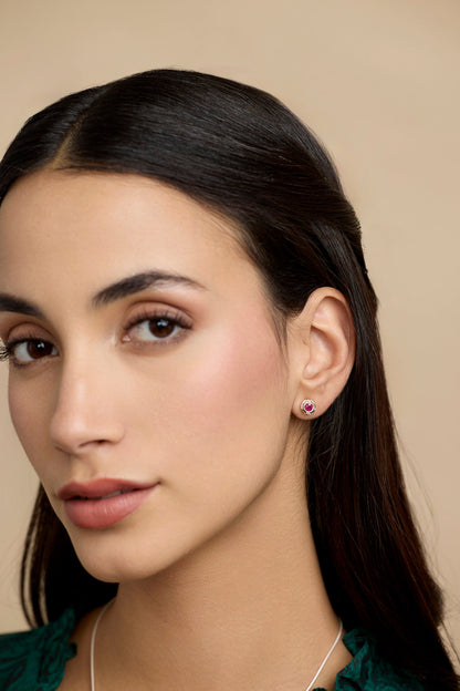 Dark-haired model wearing ruby stud earring