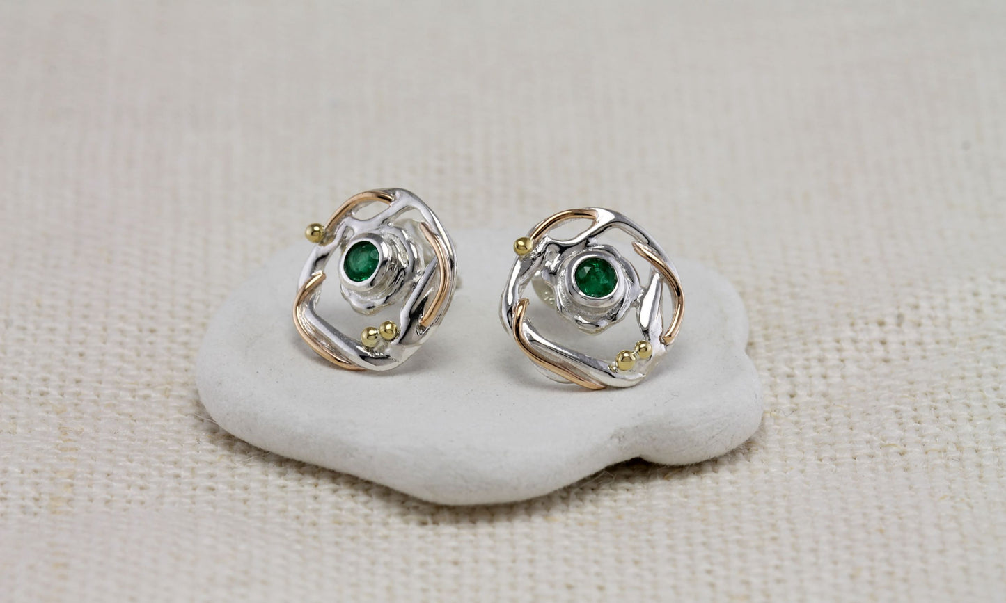 Sterling Silver Circular Mixed Metal Round Emerald Stud Earrings on a white stone