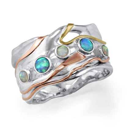 Silver ring with opal stones and gold accents on a white background