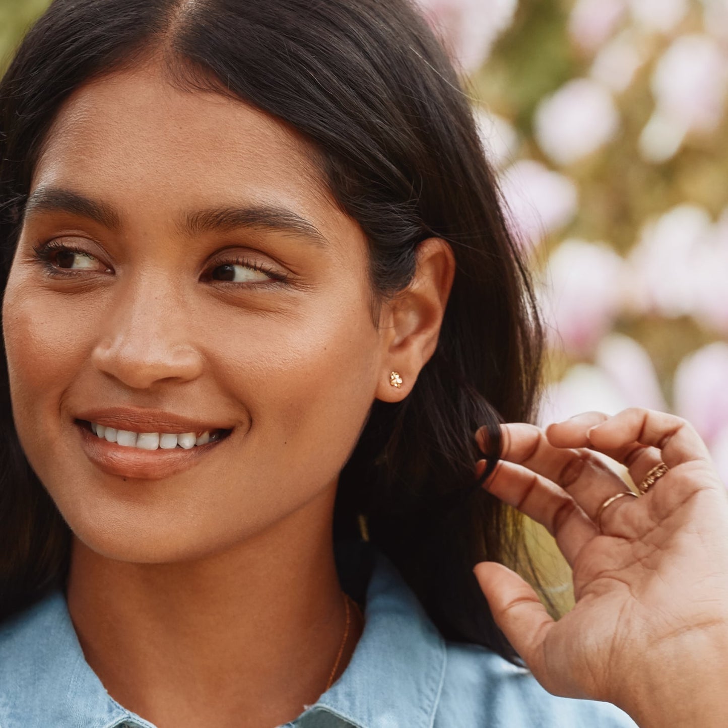 A woman wearing Alex Monroe Tiny Silver Gold Vermeil Forget Me Not Stud Earrings with Itsy Bitsy Bee