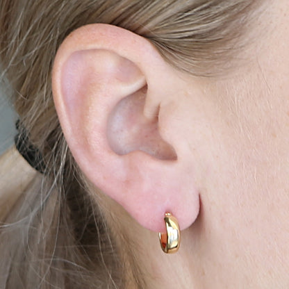 Close-up of an ear with a Joli Beau Sterling Silver 18ct Yellow Gold 12mm Small Round Huggie Hinged Hoop Earring