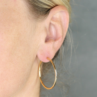 Sterling Silver 35mm Yellow Gold Vermeil  Creole Hoop Earring worn by a person with a neutral background